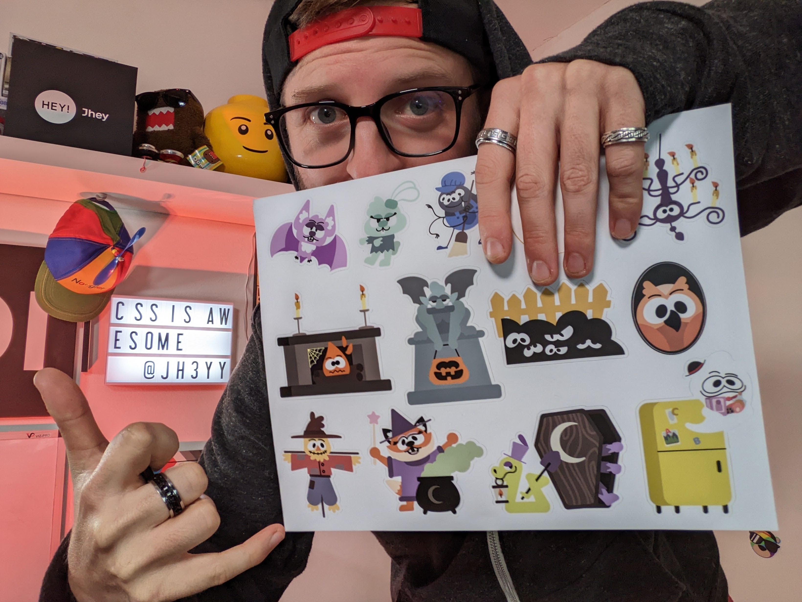 Jhey hält ein Sticker Sheet mit den Figuren aus Chrometober in der Hand.