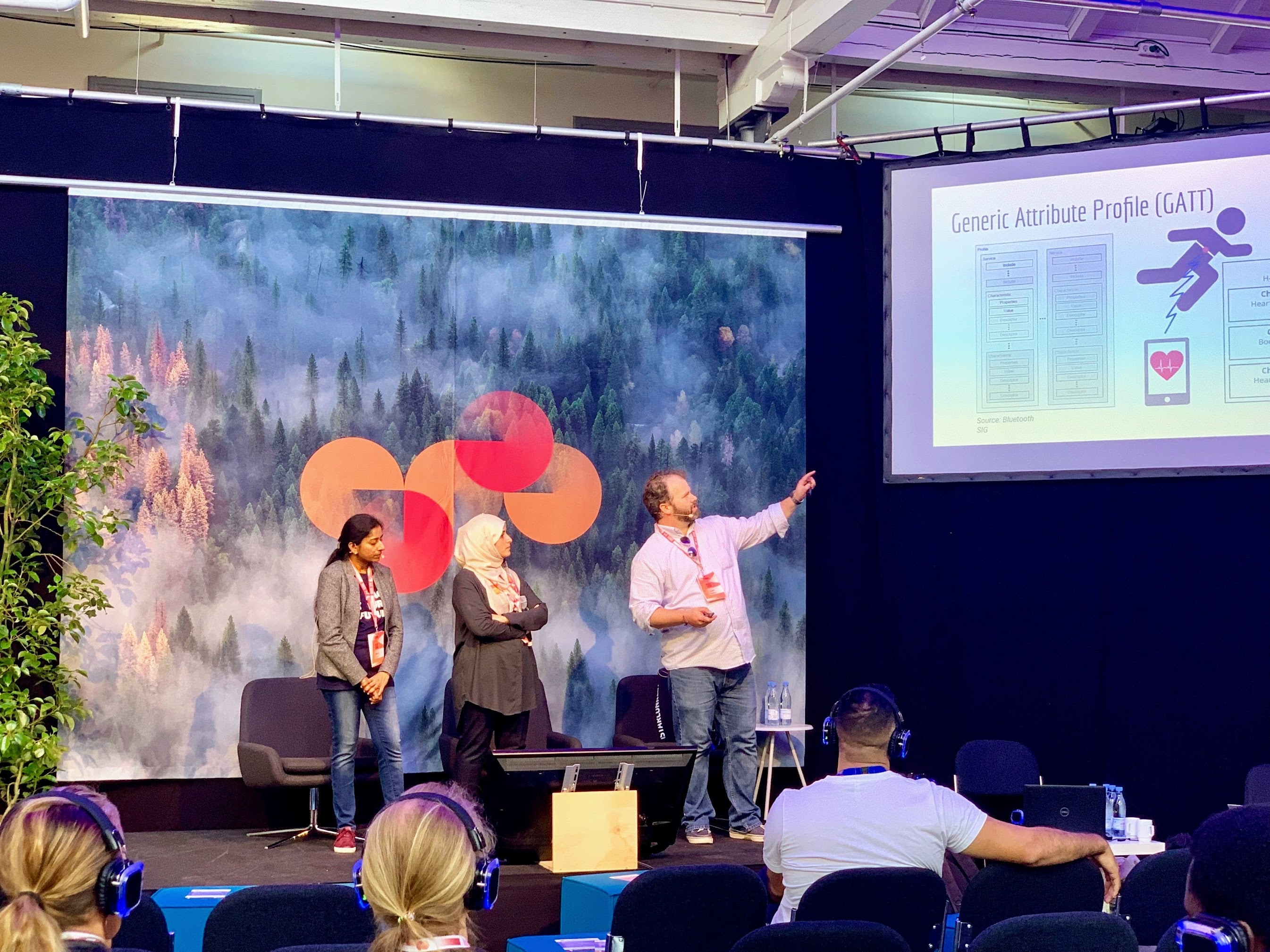 Lars apresentando no palco com outros dois palestrantes.