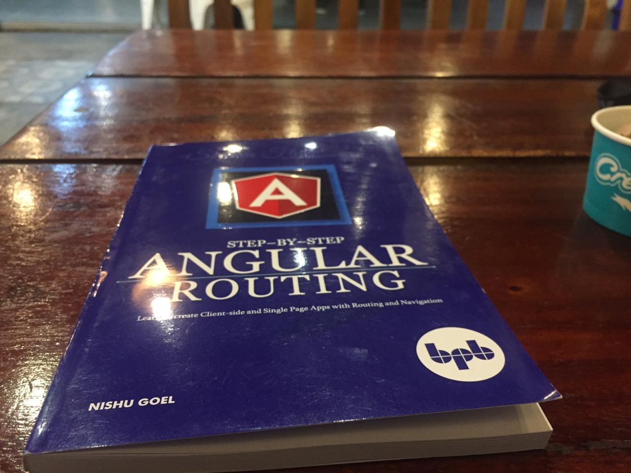 टेबल पर रखी, Angular रूटिंग किताब.