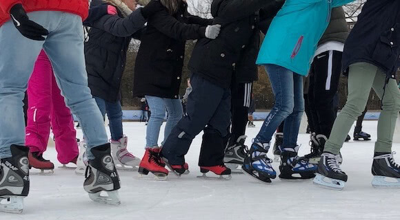 Schar von Füßen von Menschen aus der Eissporthalle.